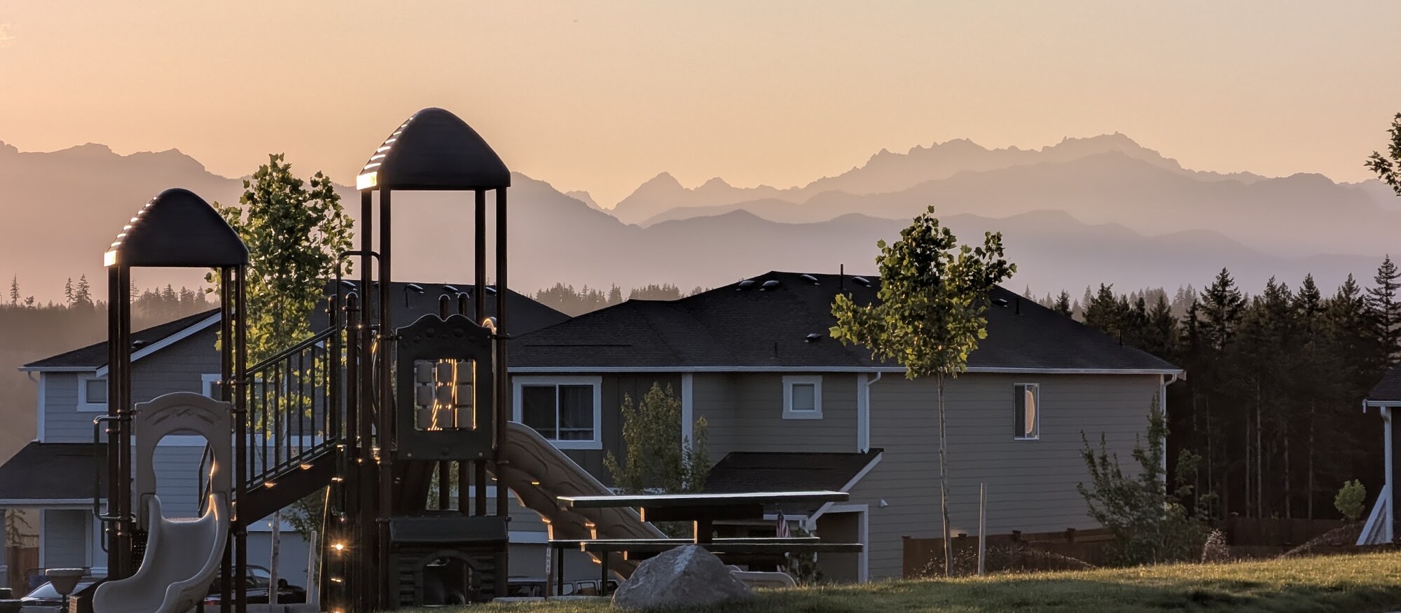 Olympic Ridge main park playground at sunset with the Olympic Mountains in the distance