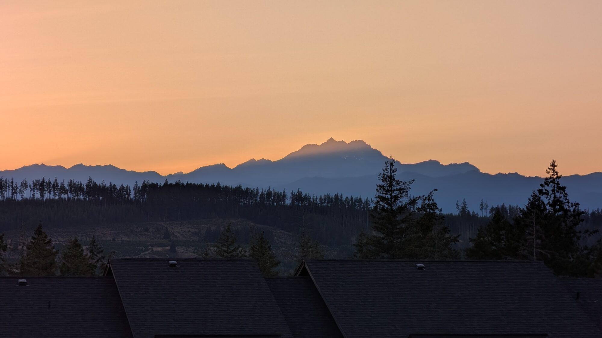 The Brothers and the Olympic Mountains silhouetted at dusk above Olympic Ridge rooftops