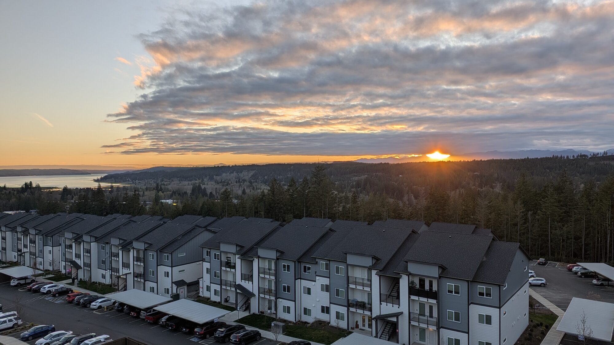 Olympic Ridge townhomes and parking areas at dusk with the sun setting over Hood Canal